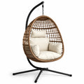 Sillón colgante de mimbre sintético marrón con cojines crema